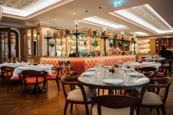 Restaurant with rose pink tiled bar and white marble-topped tables
