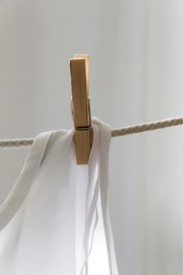 White sheet attached to a clothes line with a wooden peg