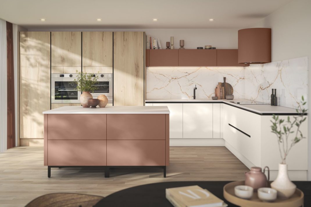 Kitchen with dusty pink cabinets, pale wooden wall cabinets and veined white marble worktops