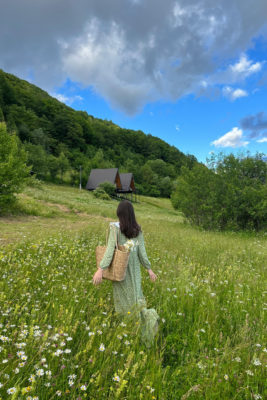 a woman in a green dress in a field of wildflowers