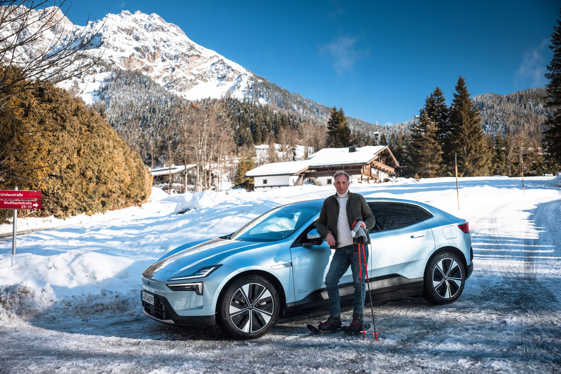 Simon de Burton on skis next to a white Polestar EV