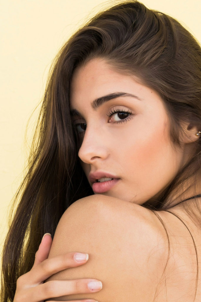 woman with brunette hair and glowing skin