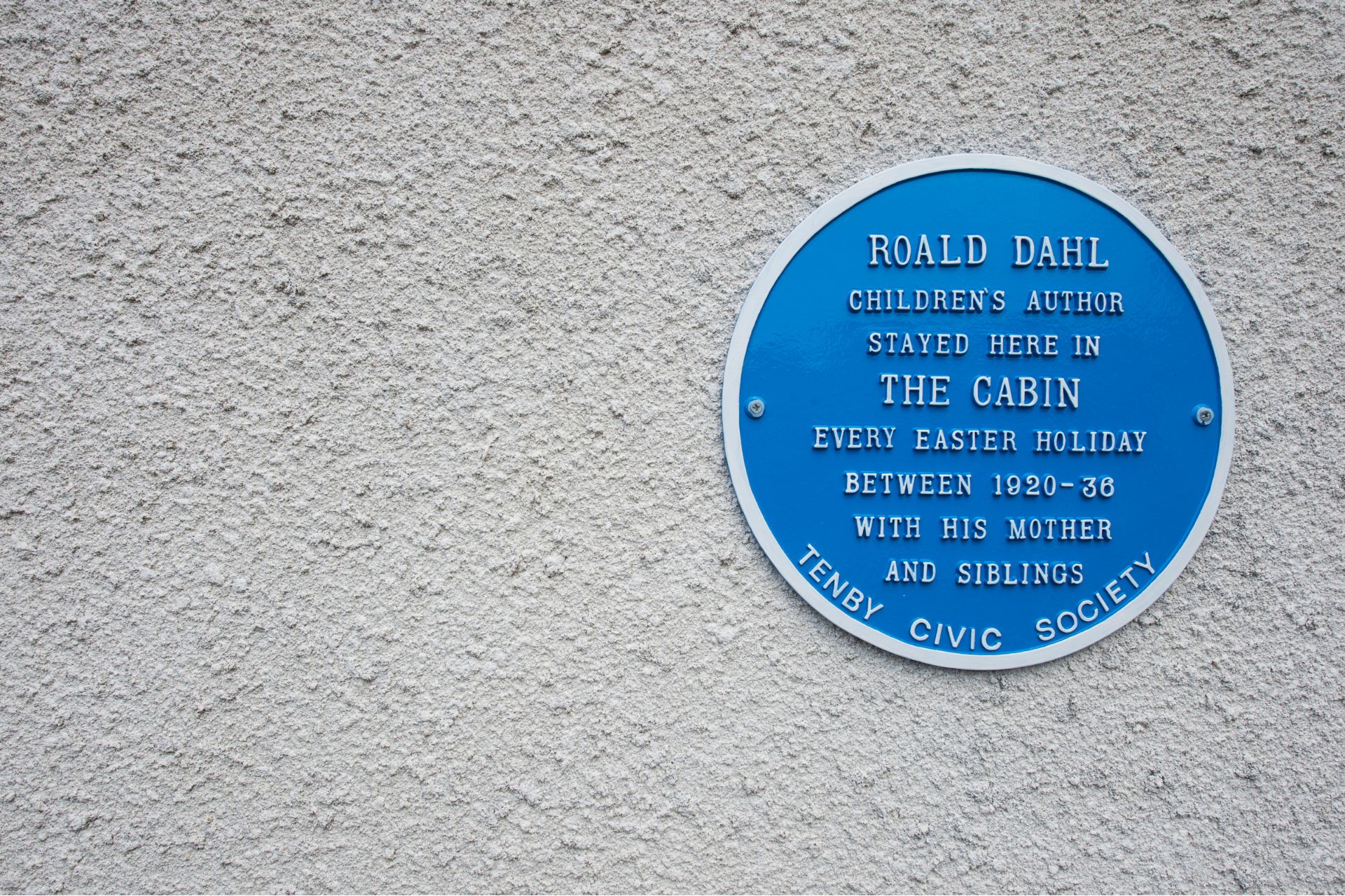 Blue plaque on a white seafrotn cottage describing the property's significance to Roald Dahl
