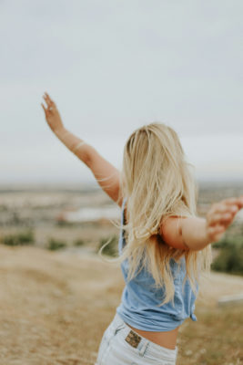 Woman with her arms lifted on a beach