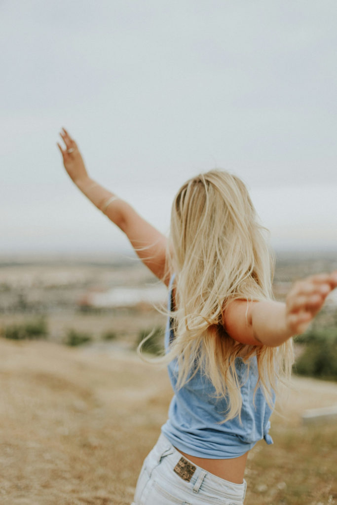 Woman with her arms lifted on a beach