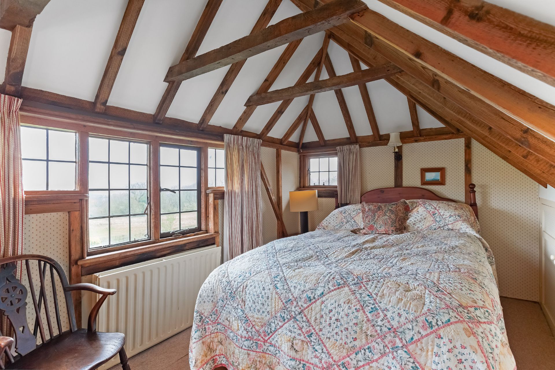 Bedroom with vauled ceiling and a floral quilt