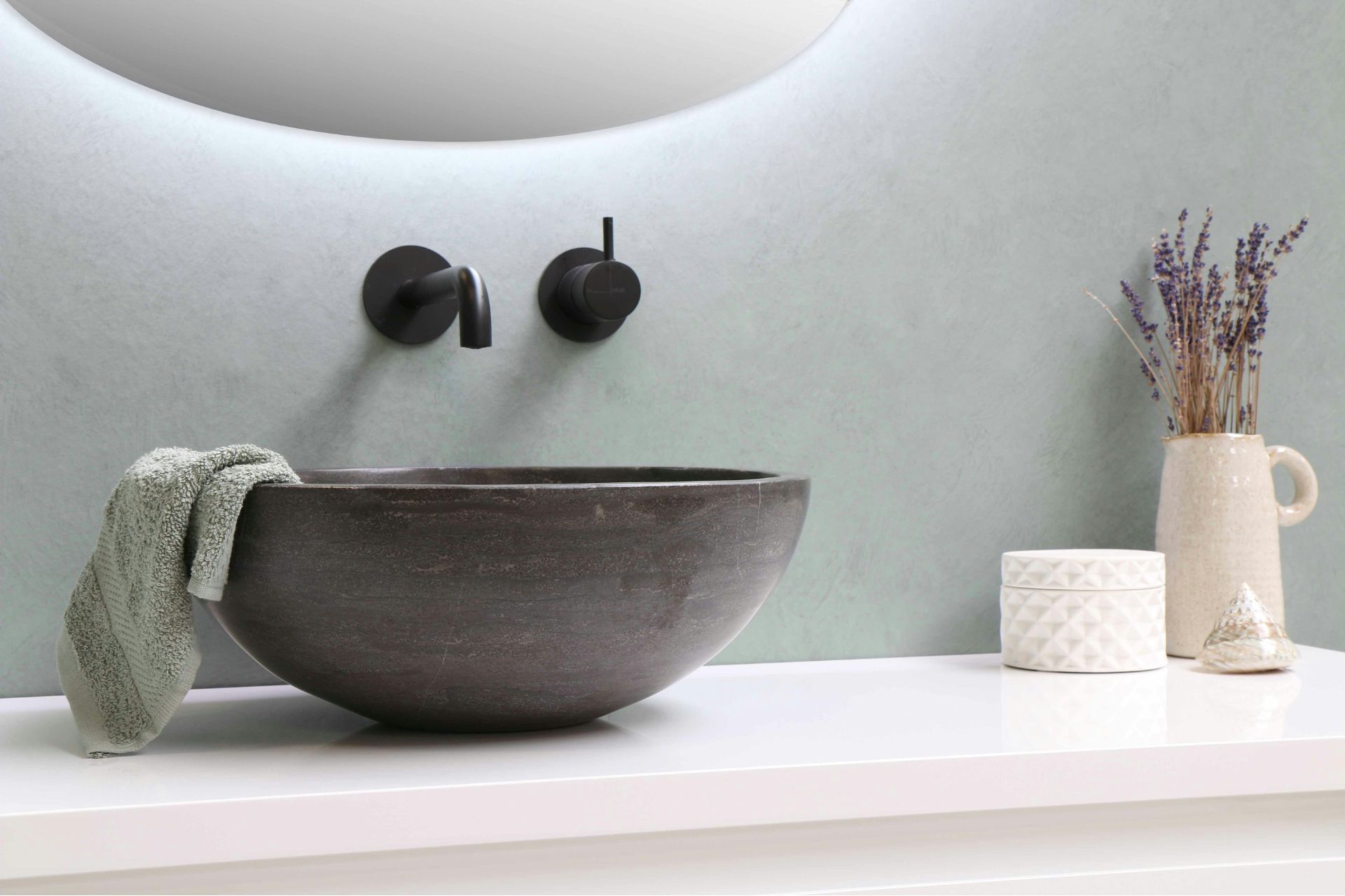 Bathroom with white counter, concrete sink basin and a pale blue feature wall