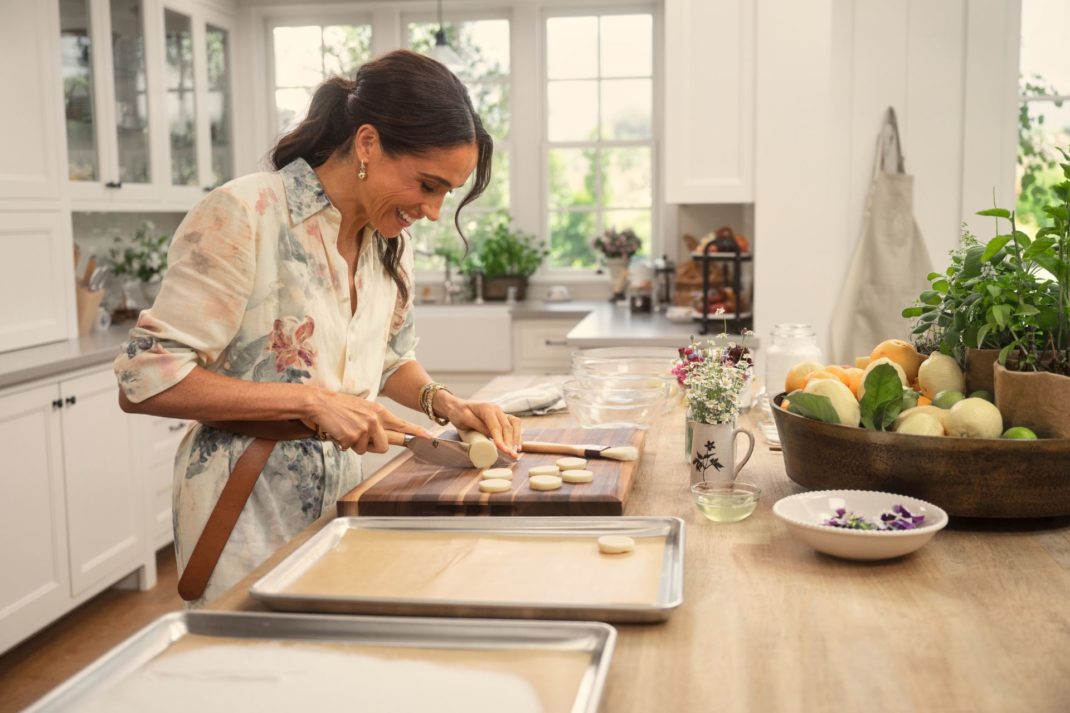 Meghan Markle in a white farmhouse kitchen, preparing a tray of cookies,