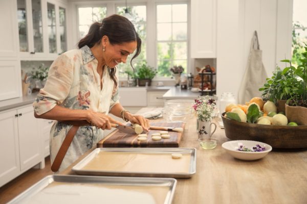 Meghan Markle in a white farmhouse kitchen, preparing a tray of cookies,