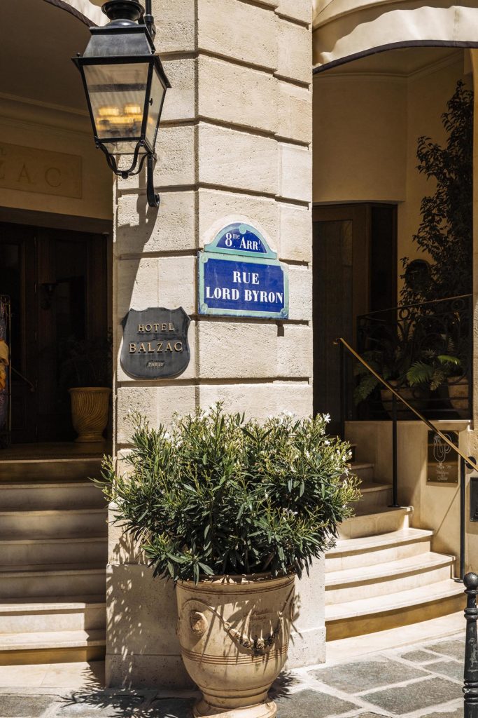 Entrance stairway to Hotel Balzac with a planter and a sign for Rue Lord Byron, Paris