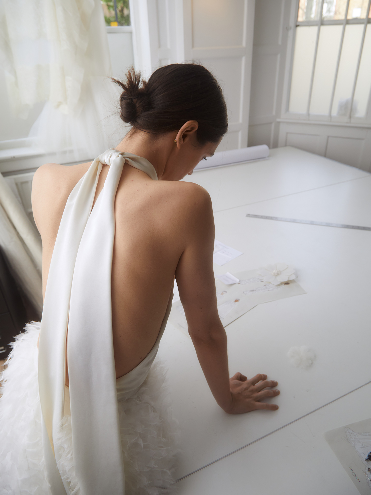 Woman sat on table in white dress