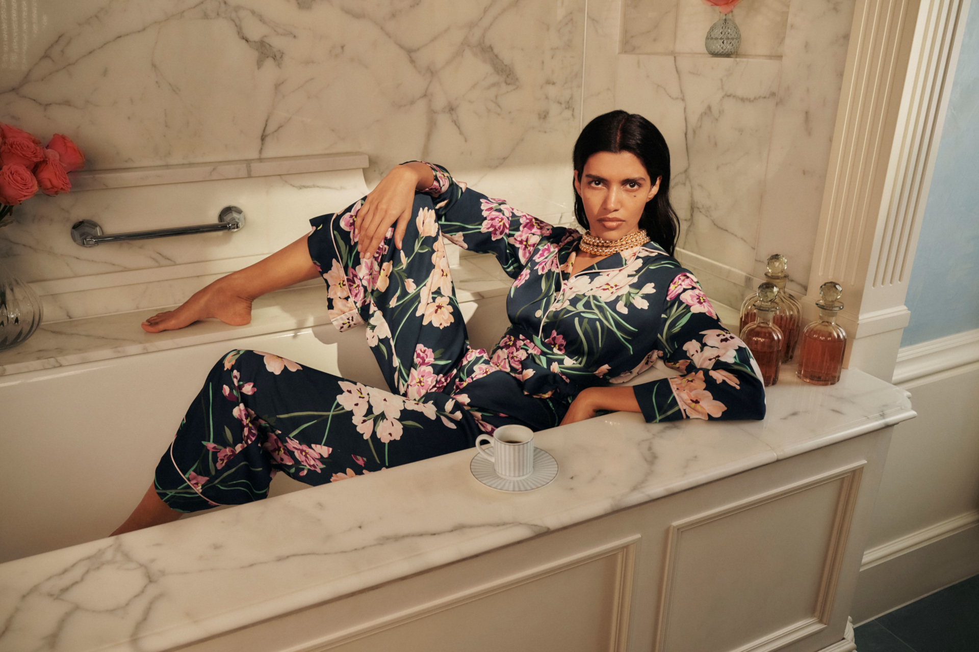 Woman wearing M&S x Olivia von Halle PJs sat in bath