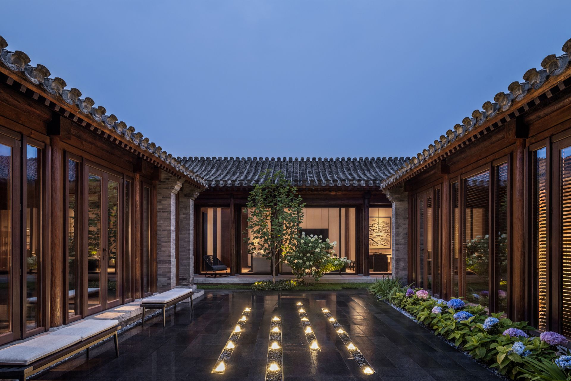 Courtyard with central floor lights and benches with flower beds at the edges