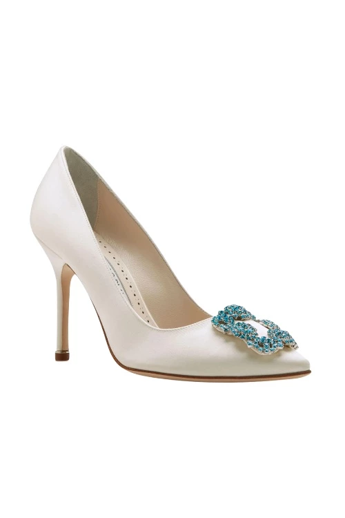 White Manolo Blahnik shoe with blue brooch