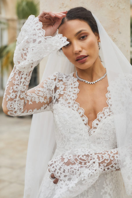 Close up of woman in wedding dress with lace sleeves and veil