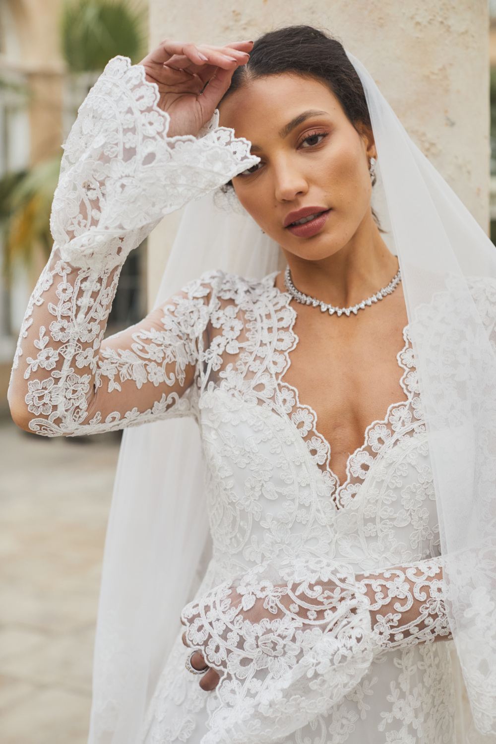 Close up of woman in wedding dress with lace sleeves and veil
