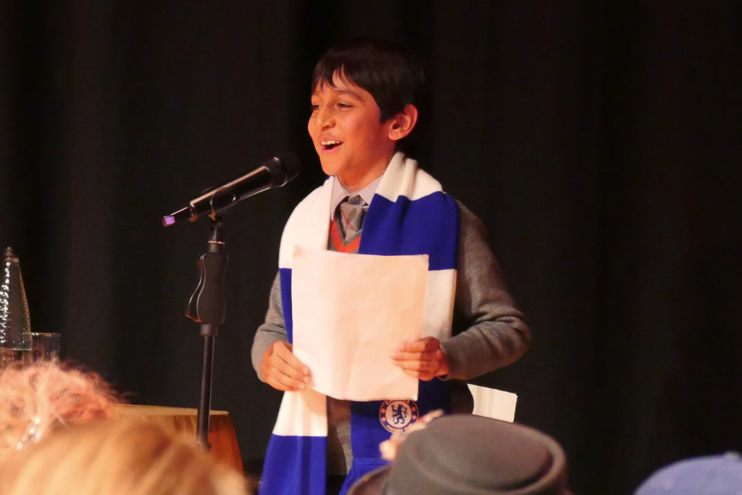 Westminster Under Student in uniform reciting poetry with a chelsea scarf on