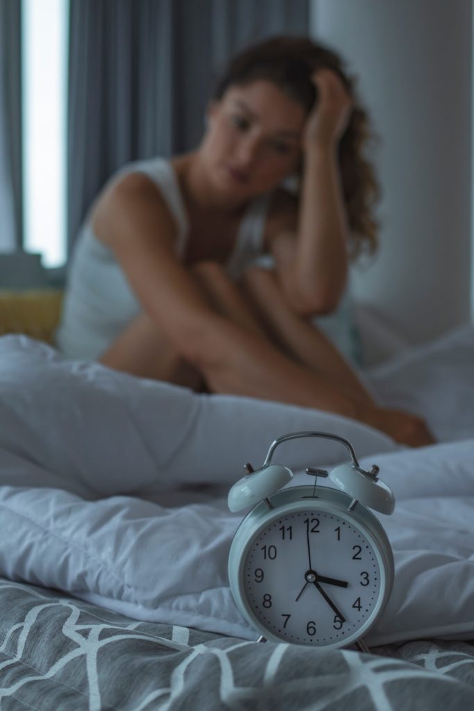 Woman looking at alarm clock | marathon sleep
