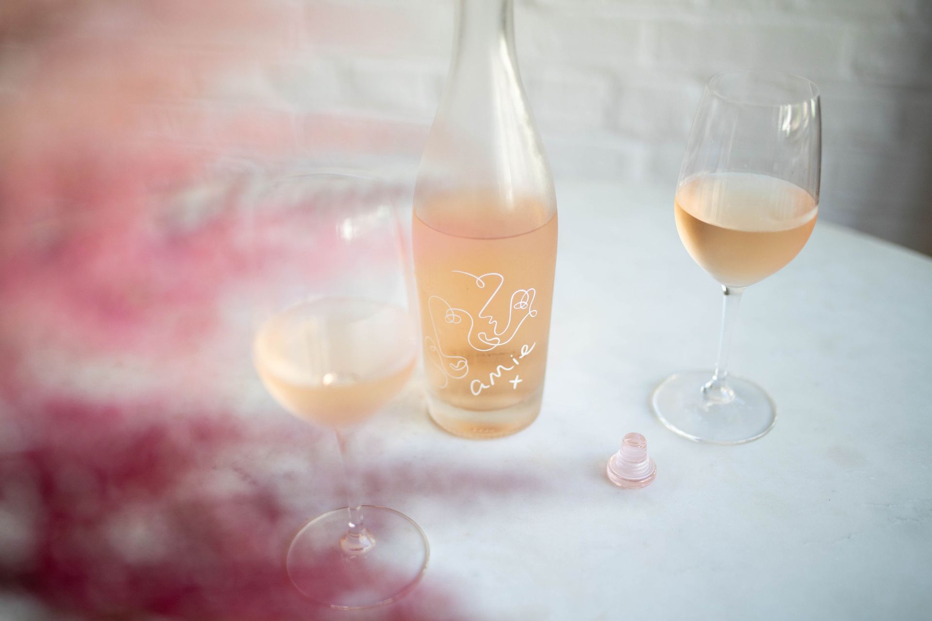 Bottle of amie rose with two glasses beside it