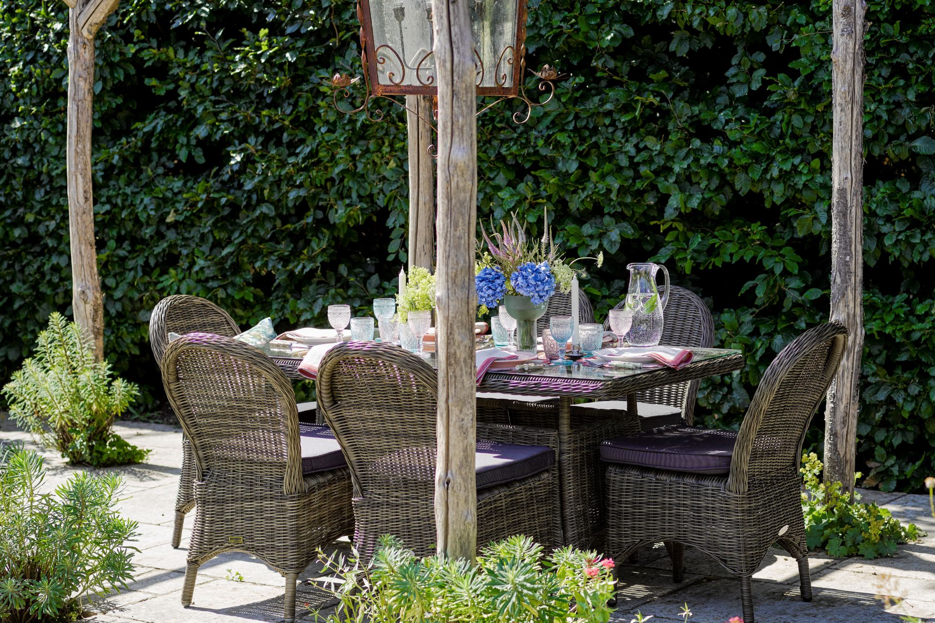 Wicker dining set below wooden pergola