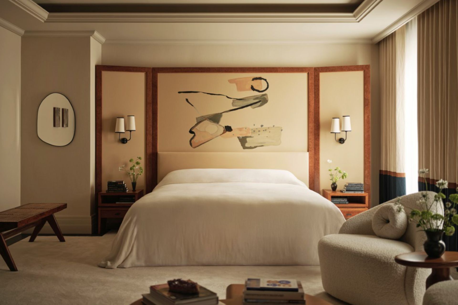 Bedroom with oversized headboard and cream bedding