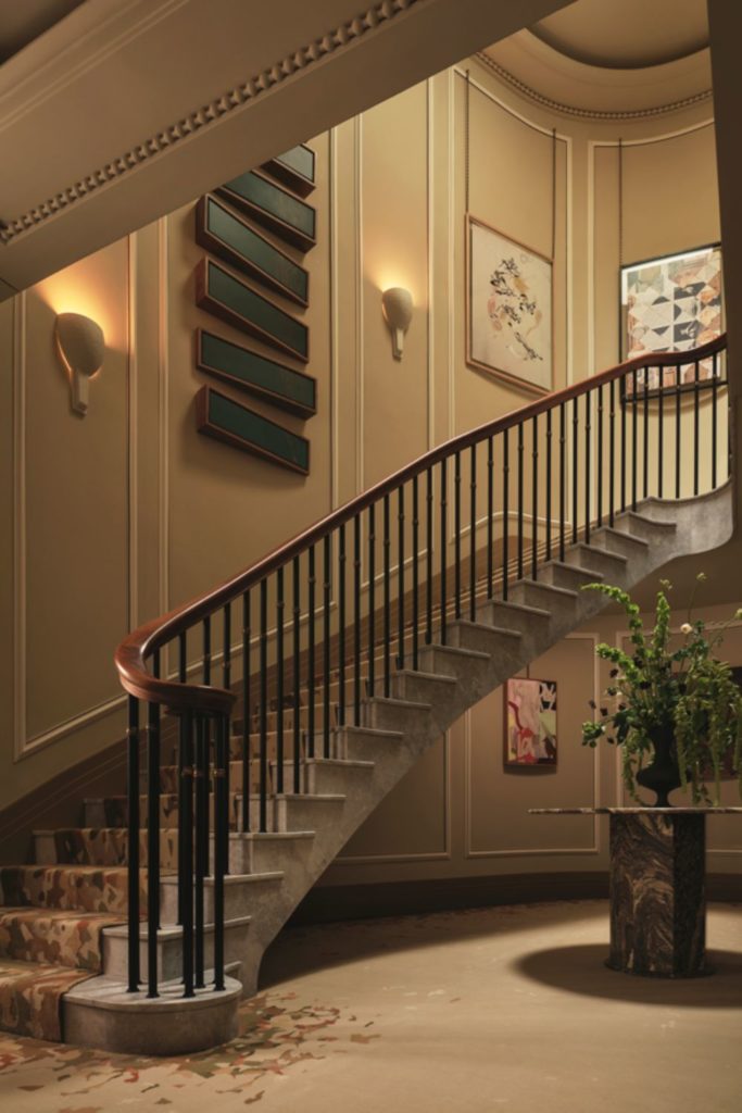 Hallway with sweeping stiaircase and marble floors