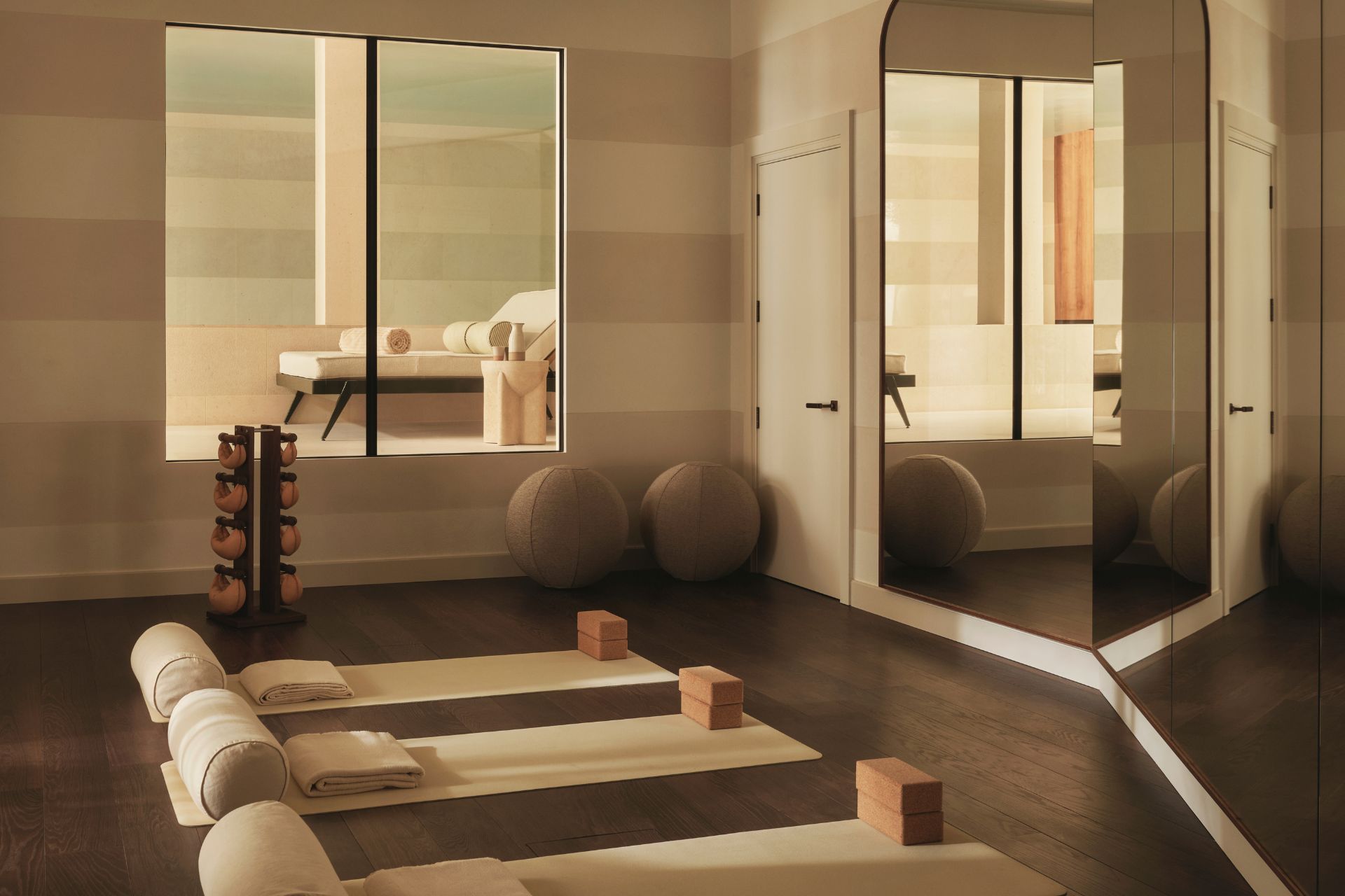 Mirrored yoga studio with cream mats and dark wooden floors