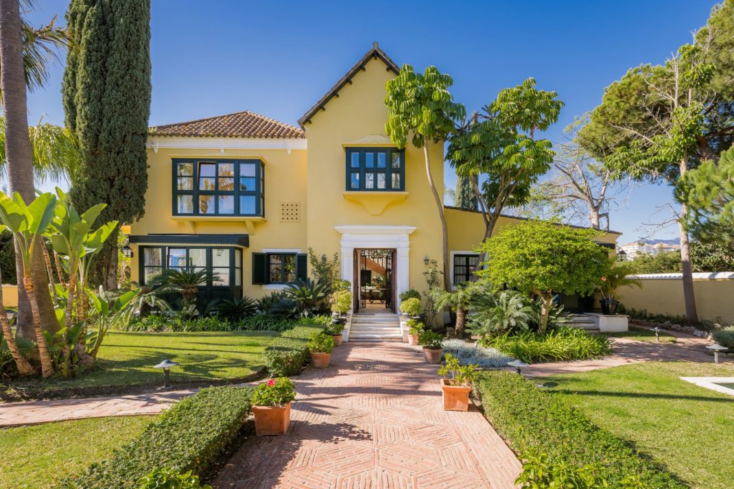 Spanish villa with butter yellow exterior and lush gardens