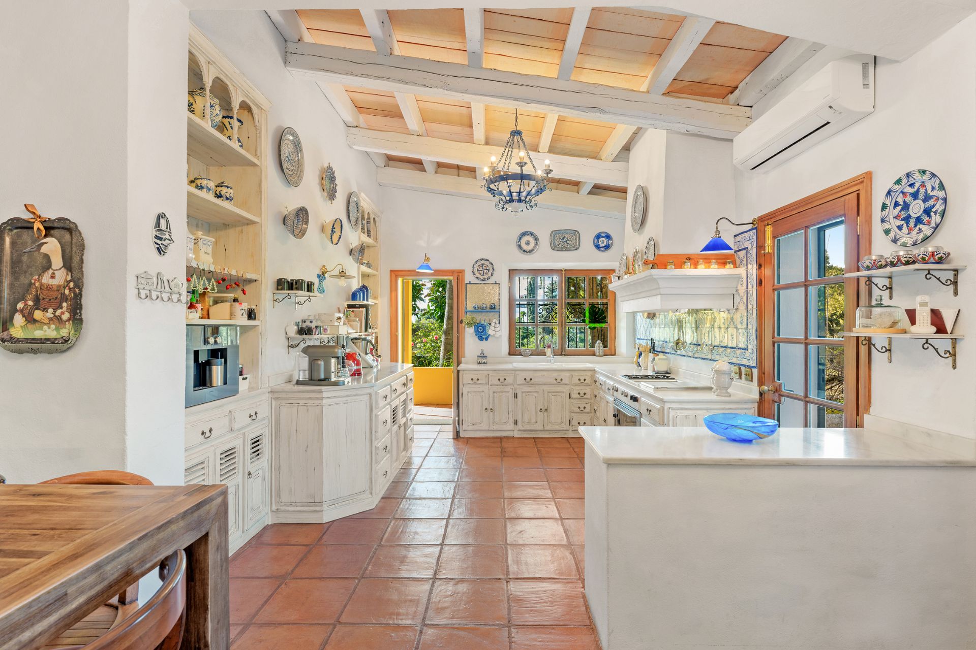 Villa kitchen with stone floors and white cabinets