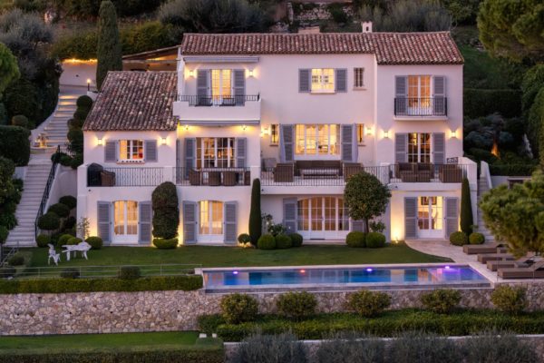 Dusk view of French Riviera villa with pool and sweeping gardens