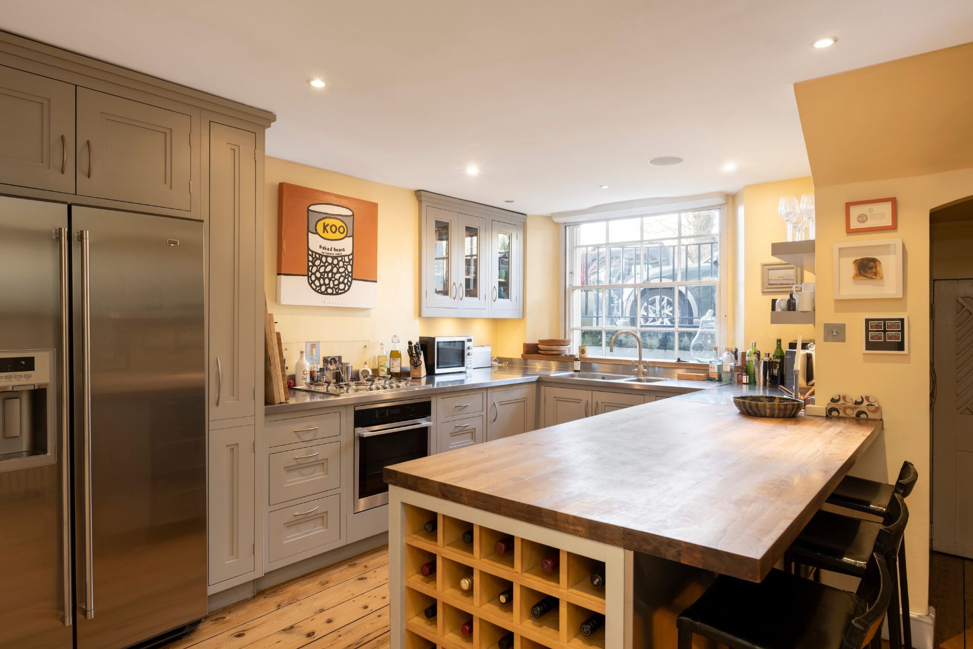 Farmhouse-style kitchen with Shaker cabinets and a wooden island with a built-in wine shelf