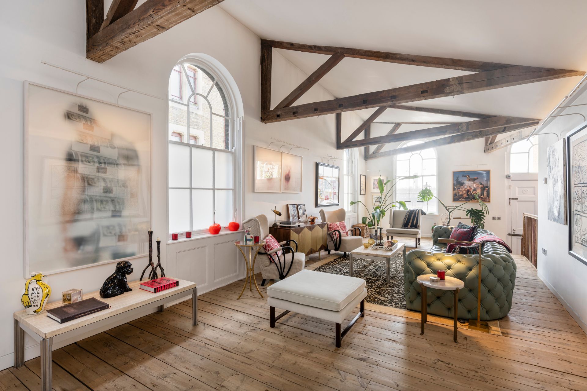 Living room with cieling beams, arched windows and wooden floors