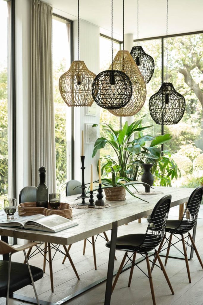 Conservatory dining area with rattan light pendants and floor-to-ceiling windows