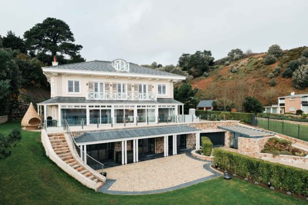 Exterior of Jersey mansion with garage beow and a sweeping staircase
