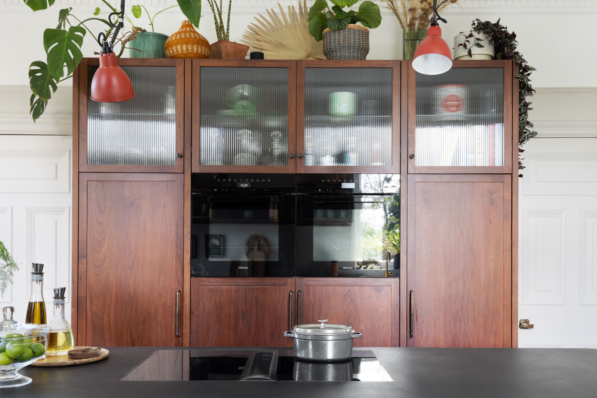 Cherry wooden kitchen with central double oven and black island