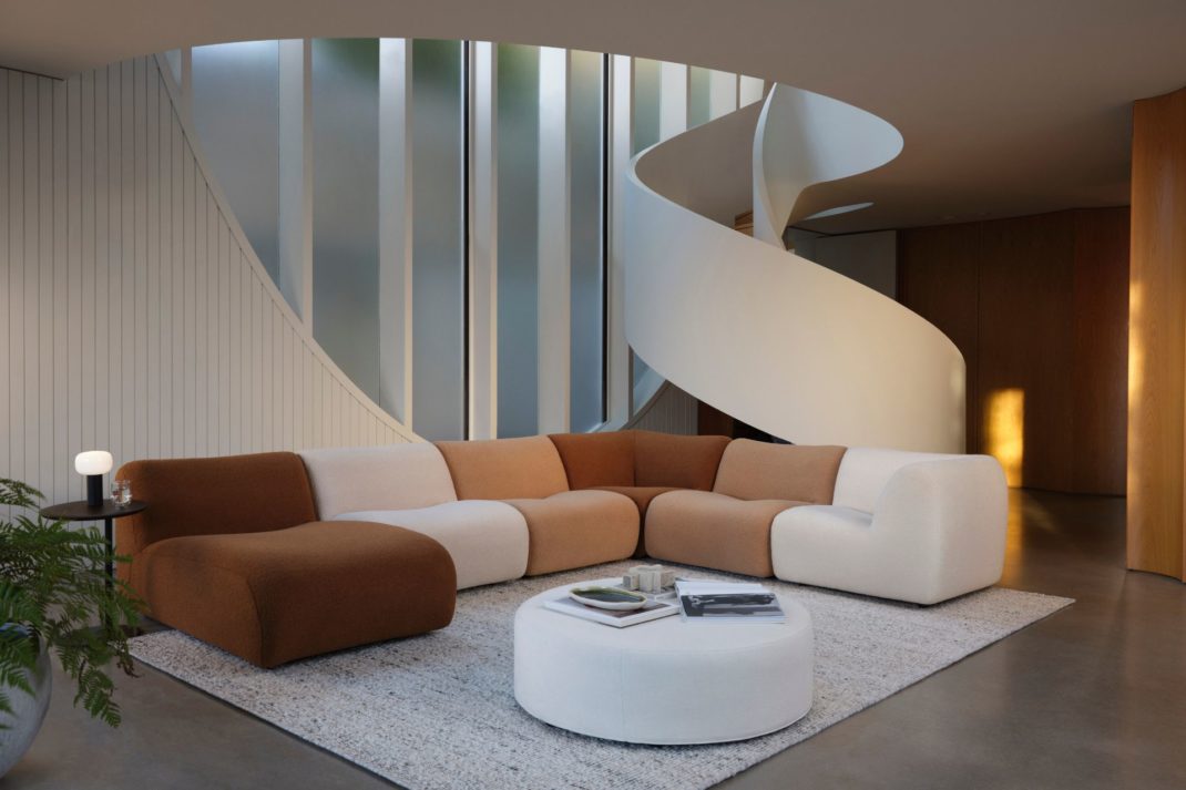 Basement living room with white spiral staircase and a brown and cream modular sofa