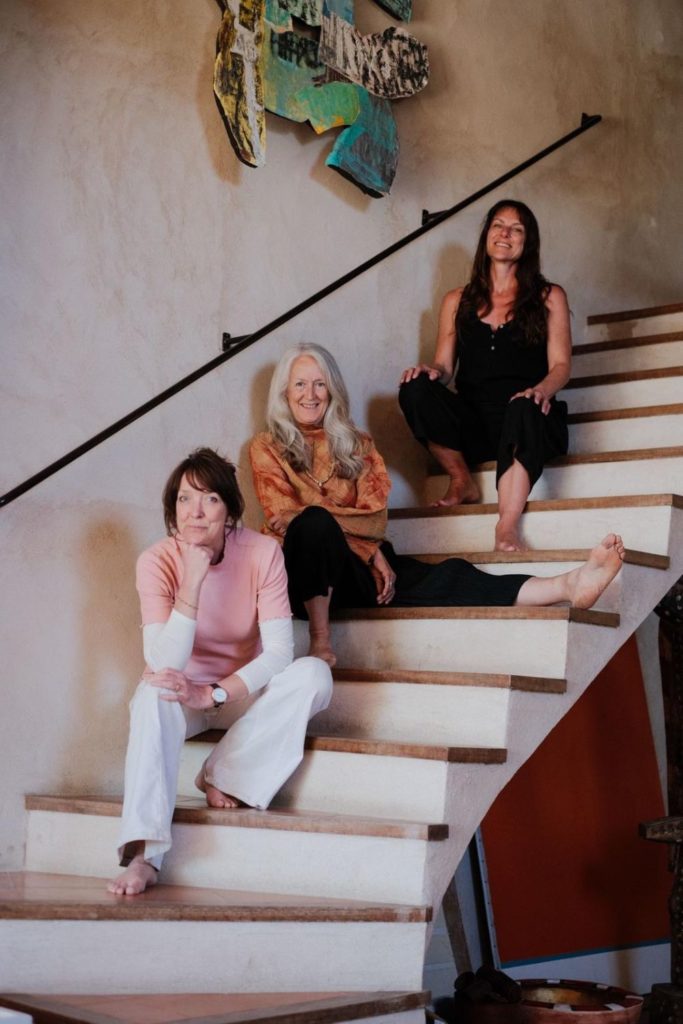Three women sitting on a white staircase