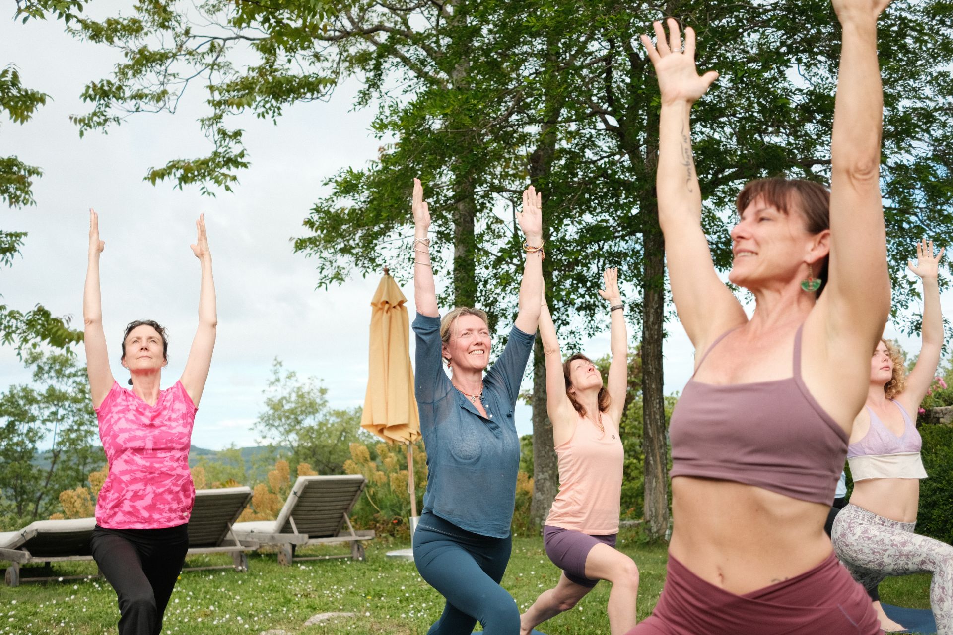 Women practising yoga in a grassy garden in Provence