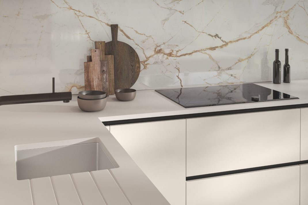 Magnet white kitchen with white veined marble splashback and wooden chopping boards
