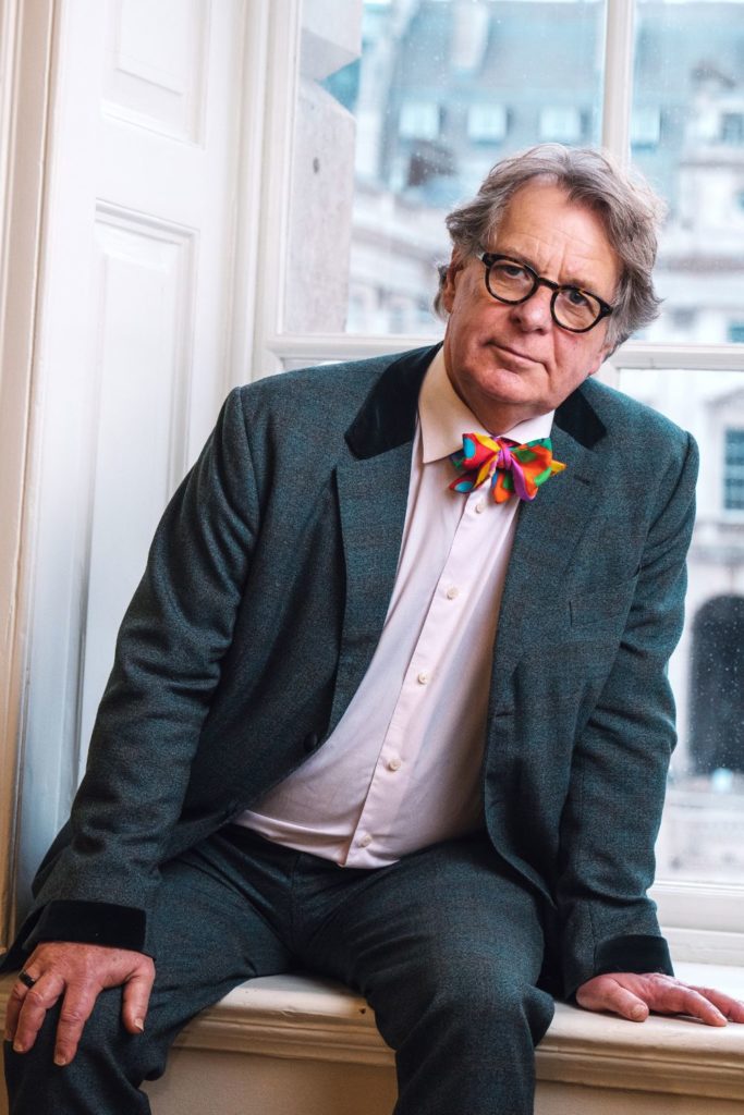 Mark Borkowski wearing a grey suit, white shirt and a multicoloured bowtie