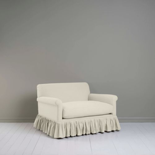 Cream loveseat in linen fabric with ruffled base