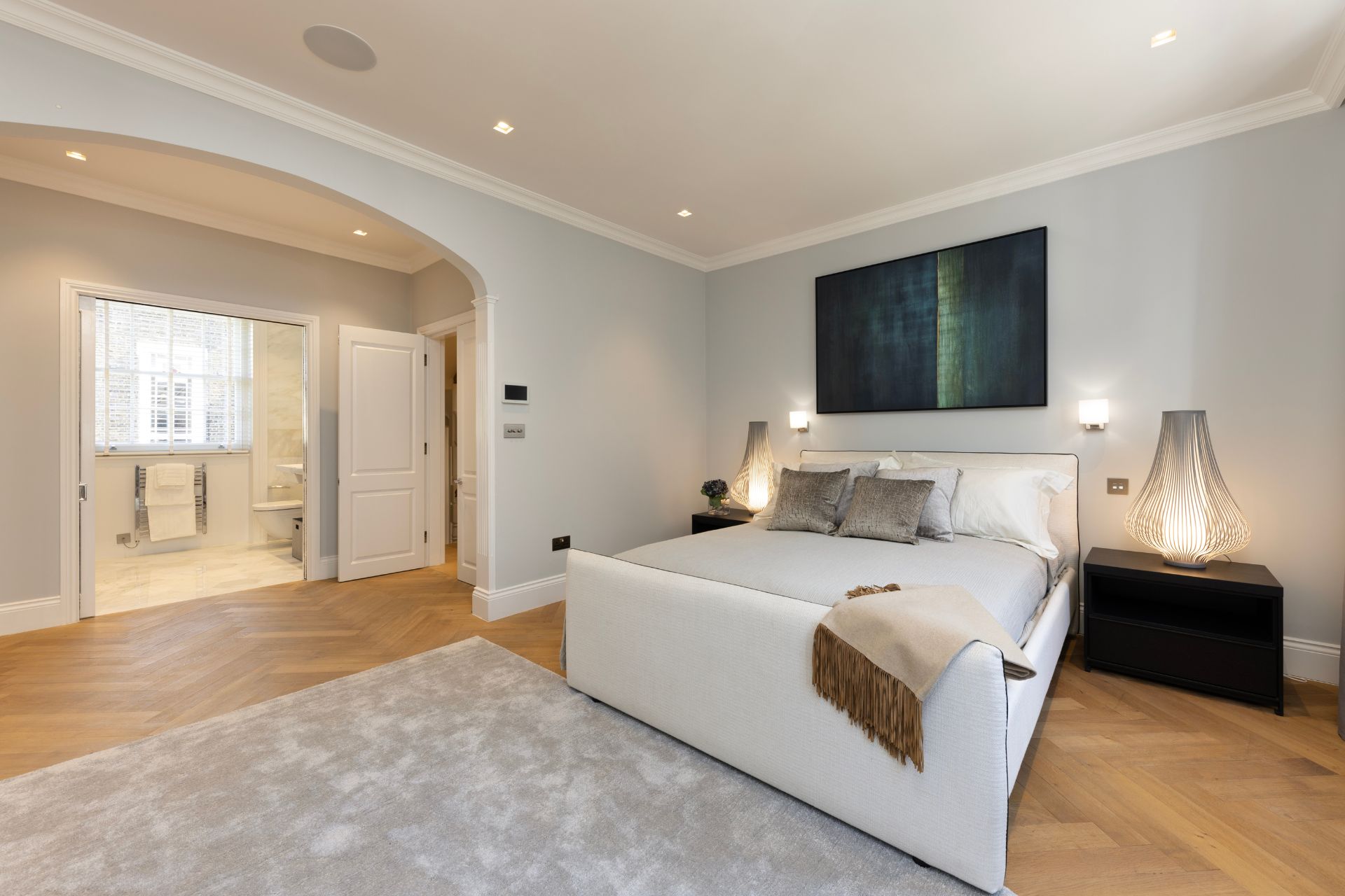Principal bedroom suite with parquet floors and a marble-clad ensuite bathroom