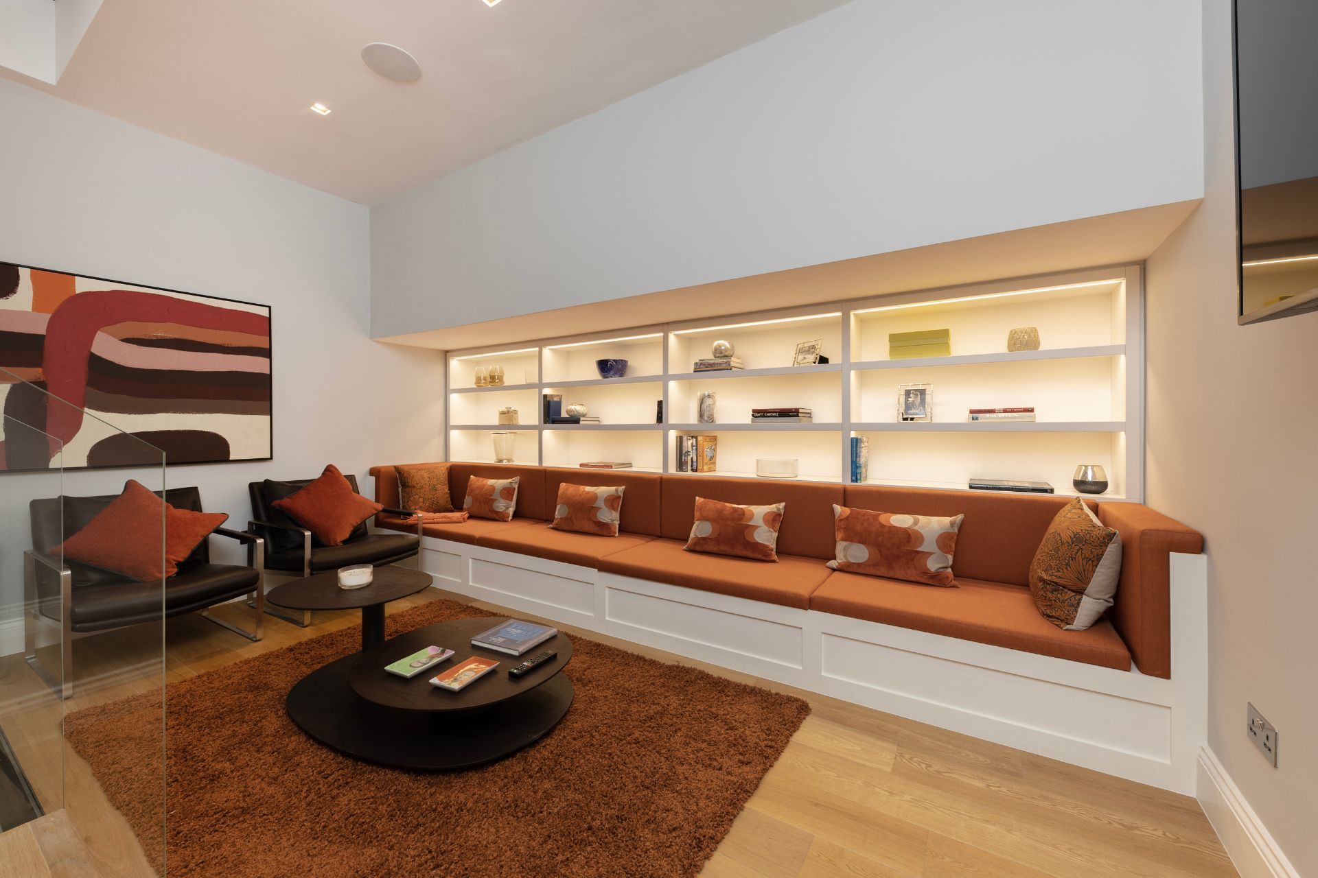 Living room with built-in shelving unit and orange corner sofa