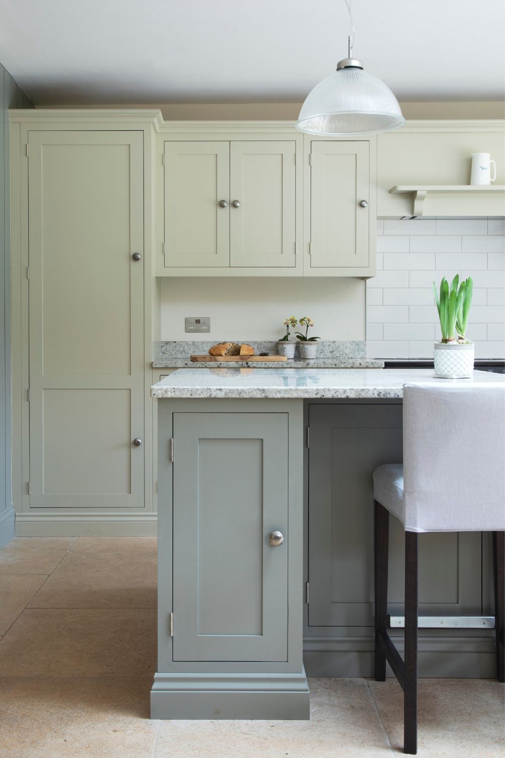 Pale green kitchen with soft grey cabinets and white bar chairs