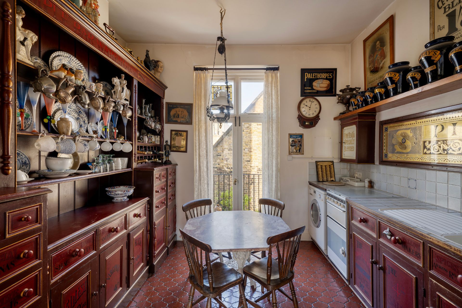 Cherry red farmhouse-style kitchen with circular wooden dining table