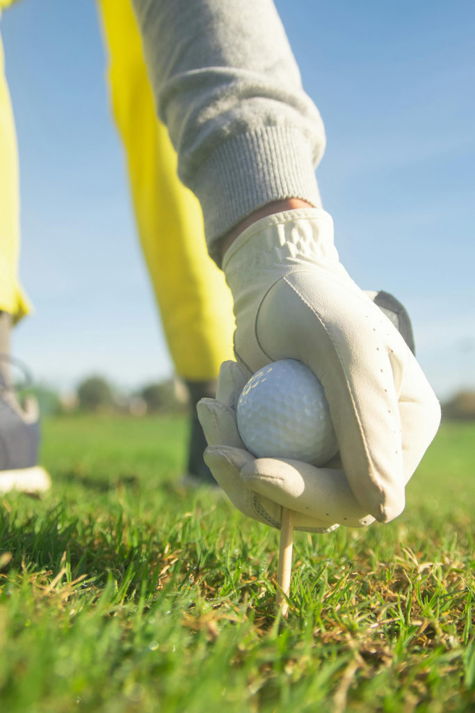 A Person Wearing a Glove while Holding a Golf Ball