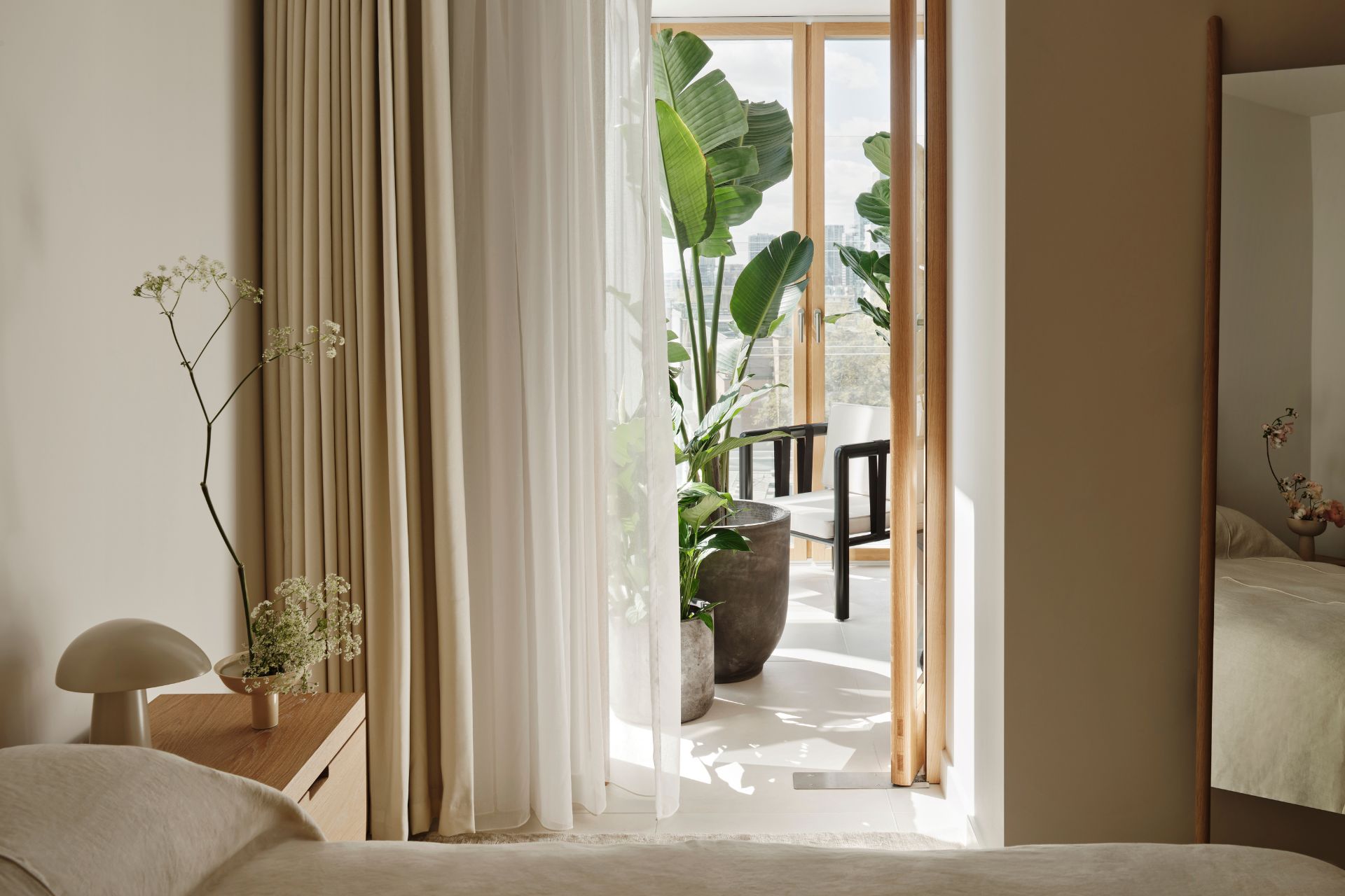 Bedroom with cream linen bedding and a winter garden