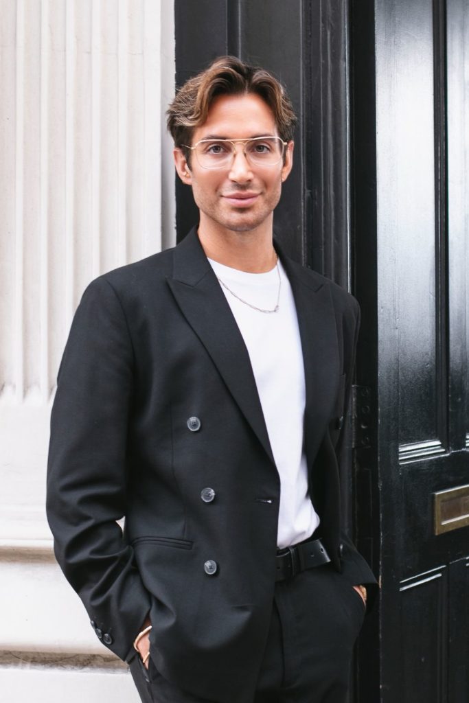 Hair stylist Tom Smith wearing a black blazer and white t shirt