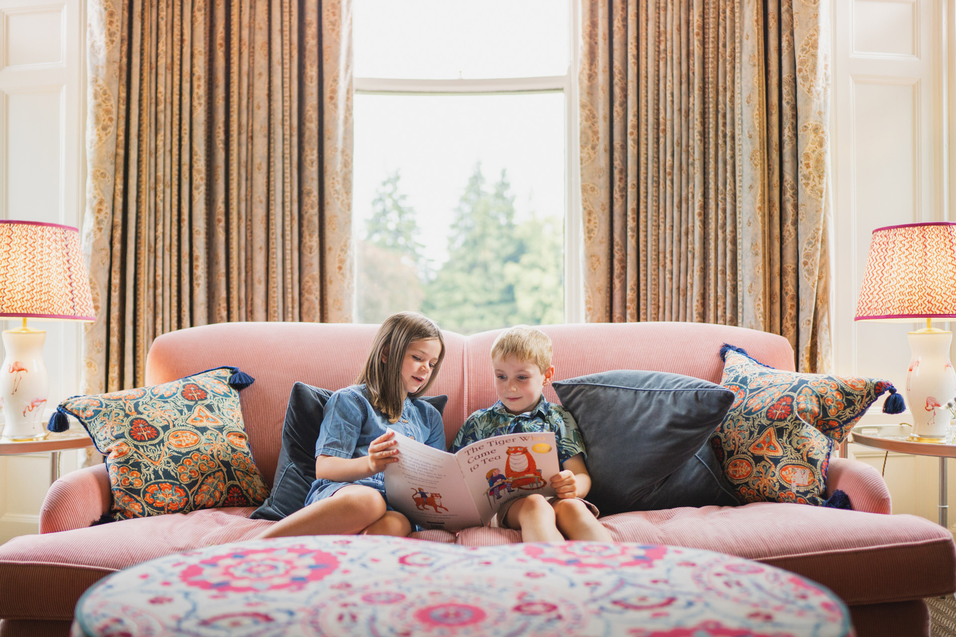 Two children reading on a sofa