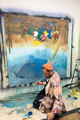 Umar Rashid in front of a large canvas